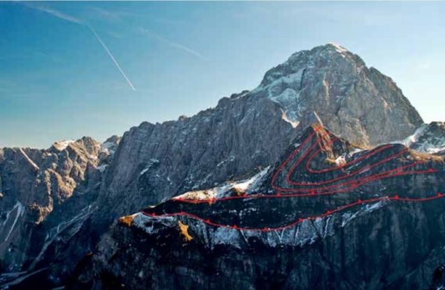 The photograph shows a mountain with red lines drawn to indicate faults.